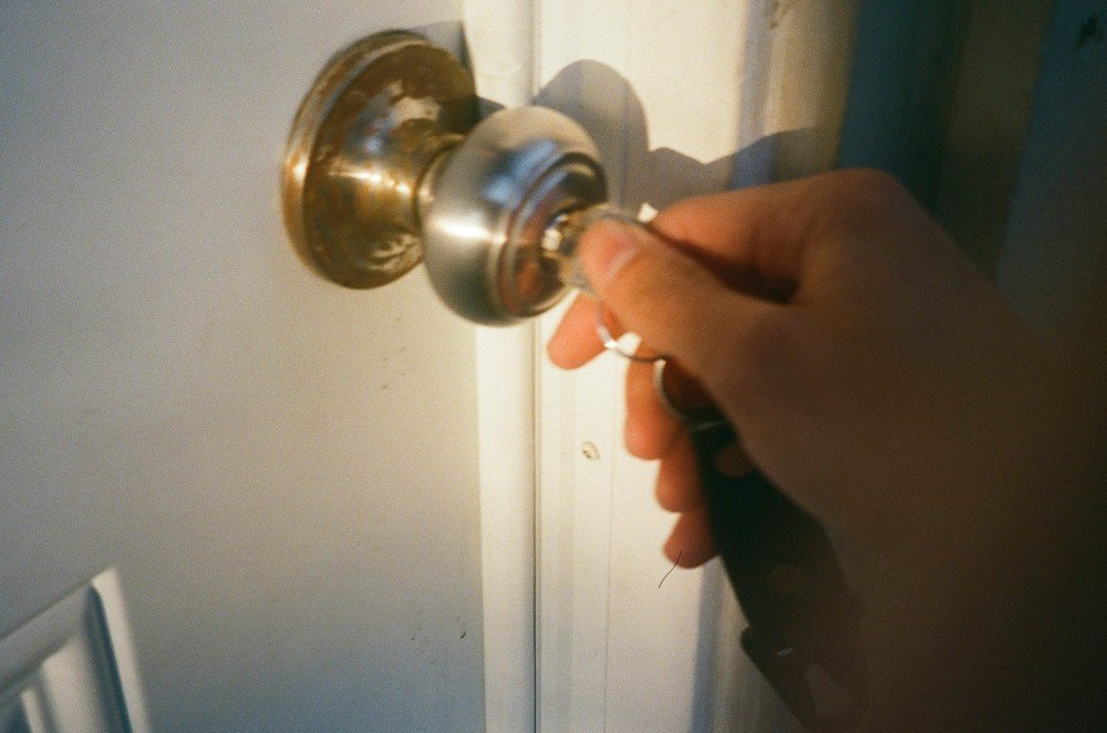 Main qui tourne une clé dans la poignée d'une porte